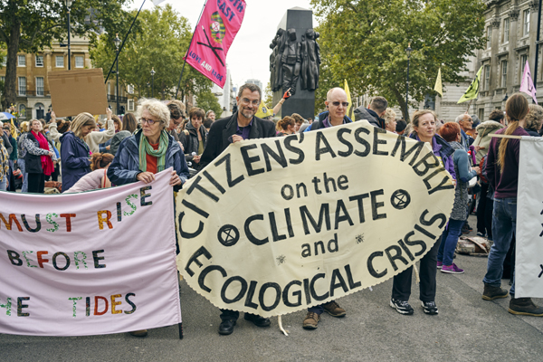 People holding signs to demand action on the climate crisis